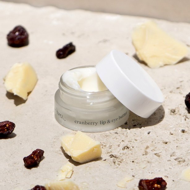 Ere Perez Cranberry Lip and Eye Butter - mood image between shea butter pieces