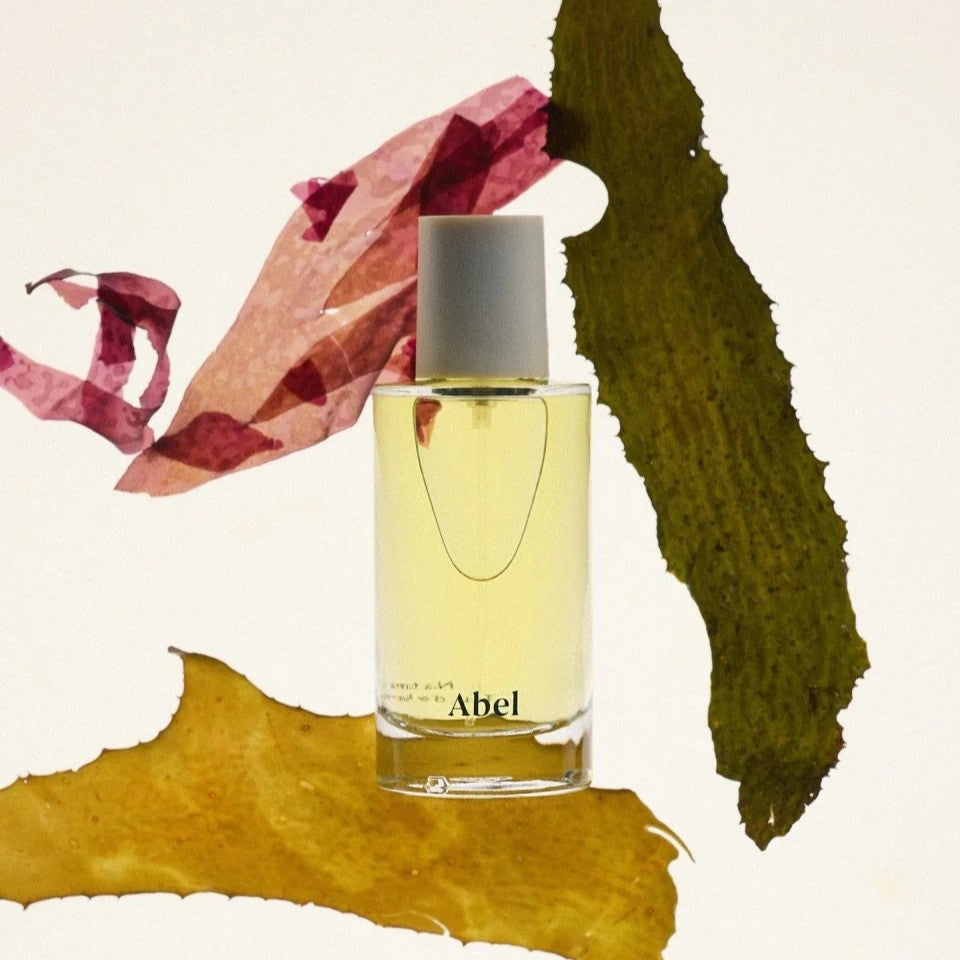 perfume ingredients are draped around a perfume bottle