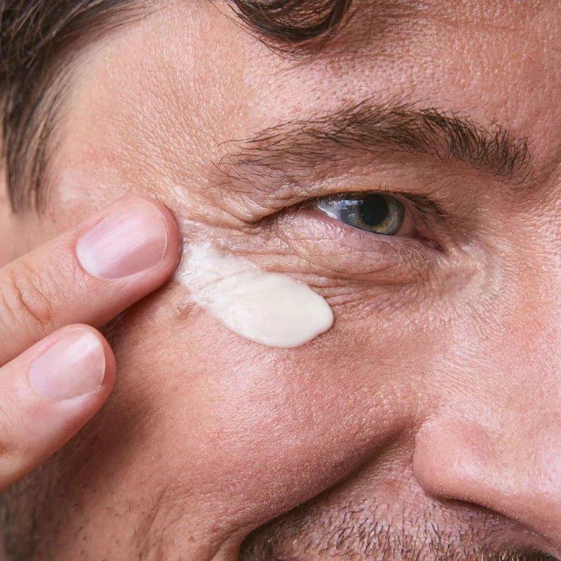 A man applies eye cream