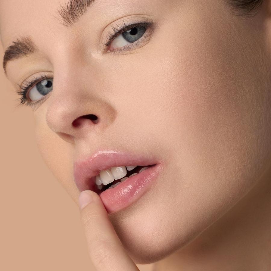 Frau trägt Le Rouge Français Achille Multi-Use Balm auf die Lippen auf