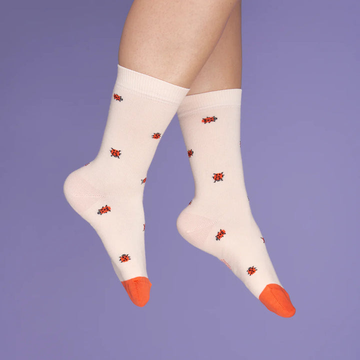 Ladybug Socks von Coucou Suzette - getragen vor lila Hintergrund