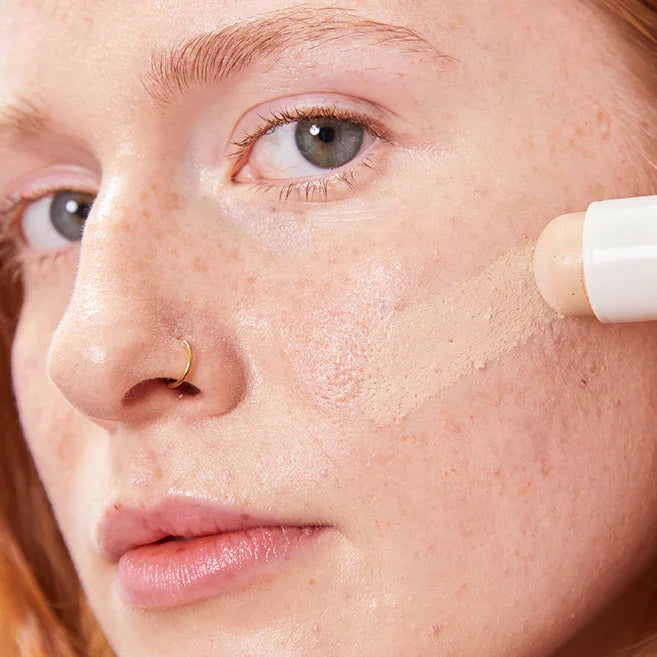 Model trägt Concealer Balm Nr. 4 Oat auf - cremige Textur für natürliches Finish