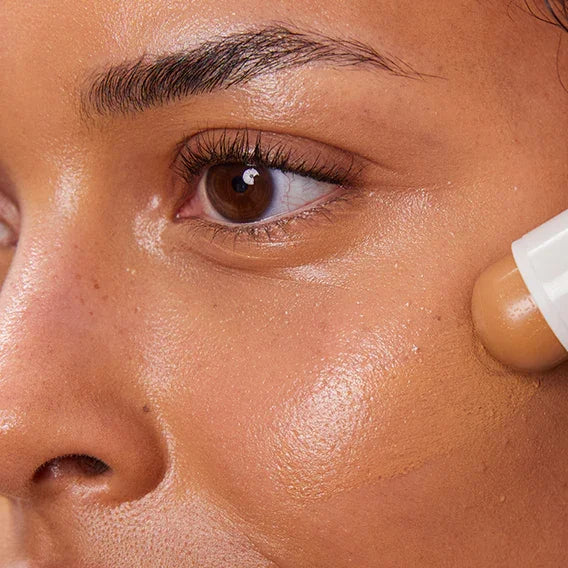 Model trägt Concealer Balm Nr. 6 Maple auf - cremiger Concealer für natürlichen Teint