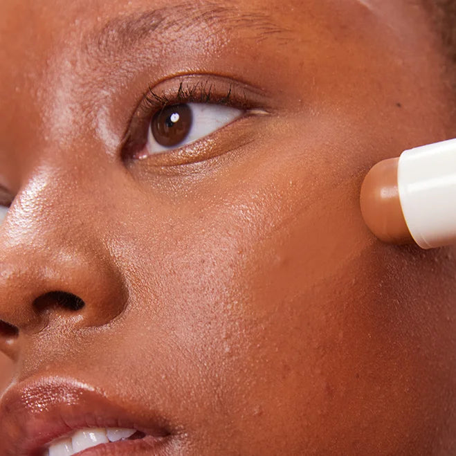  Model trägt Concealer Balm Nr. 7 Amber auf - natürlicher Concealer für dunkle Hauttöne