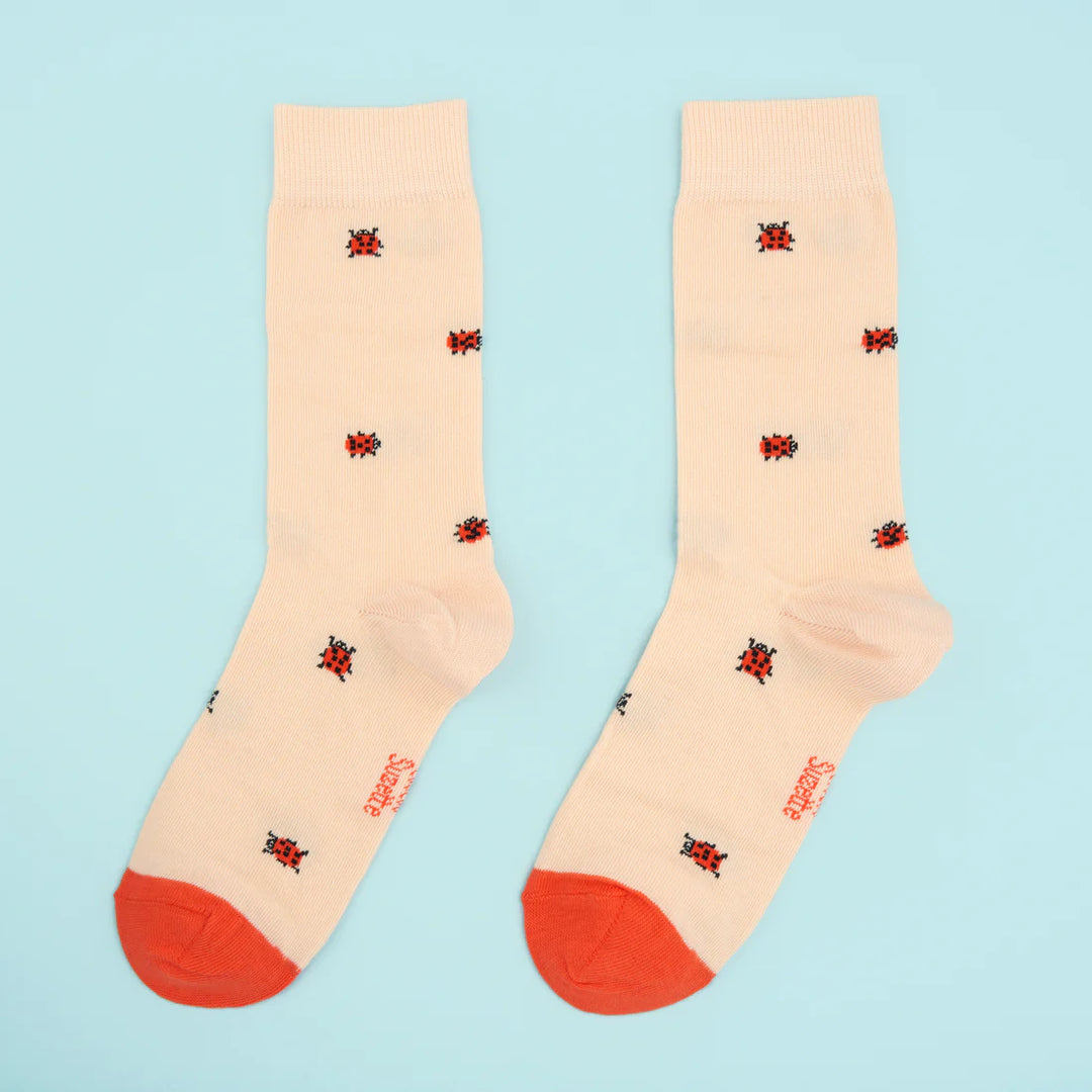 Ladybug Socks von Coucou Suzette - vor blauem Hintergrund