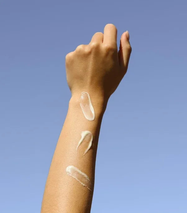 Organic and Natural Body Milk von Eco By Sonya - aufgetragen auf die Haut, Arm streckt in den Himmel