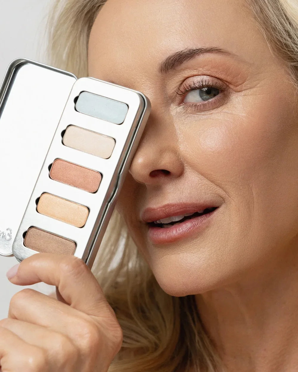 Model mit der Ere Perez Light Shimmer Lidschattenpalette und natürlich strahlendem Augen-Make-up
