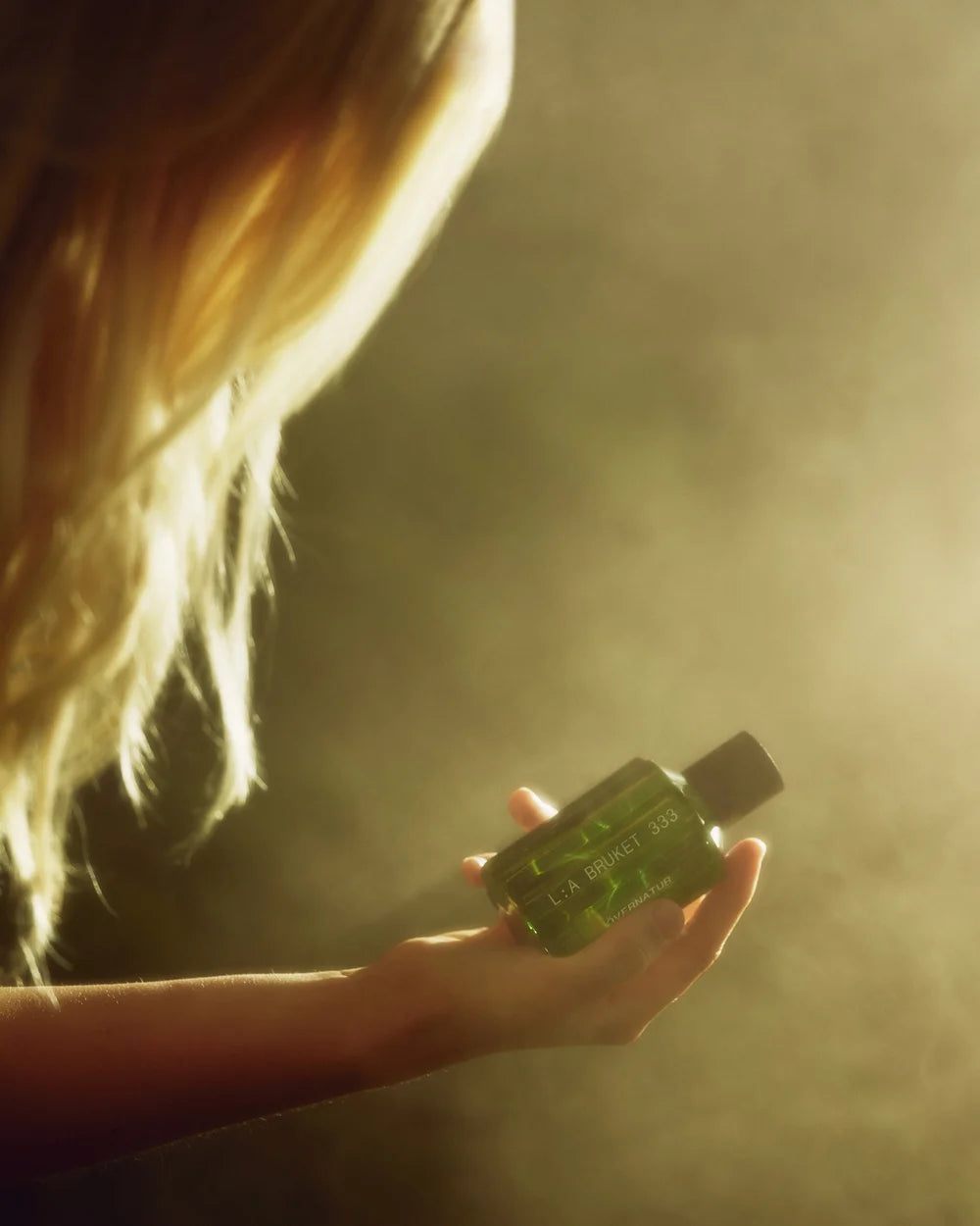 L:A Bruket Övernatur Eau de Parfum in der Hand einer Frau im warmen Sonnenlicht
