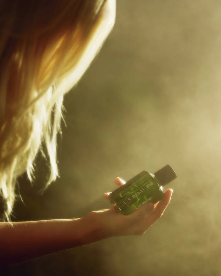 L:A Bruket Övernatur Eau de Parfum in der Hand einer Frau im warmen Sonnenlicht