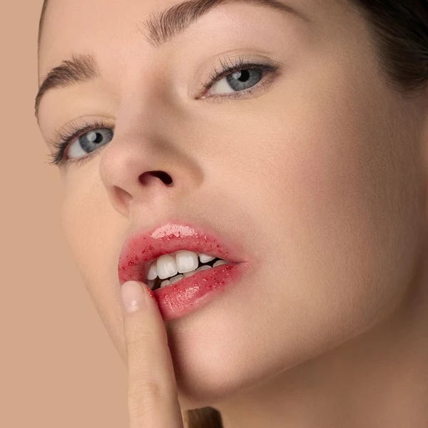 Model beim Auftragen des rosig getönten Sigrid Lippenbalsams von Le Rouge Français