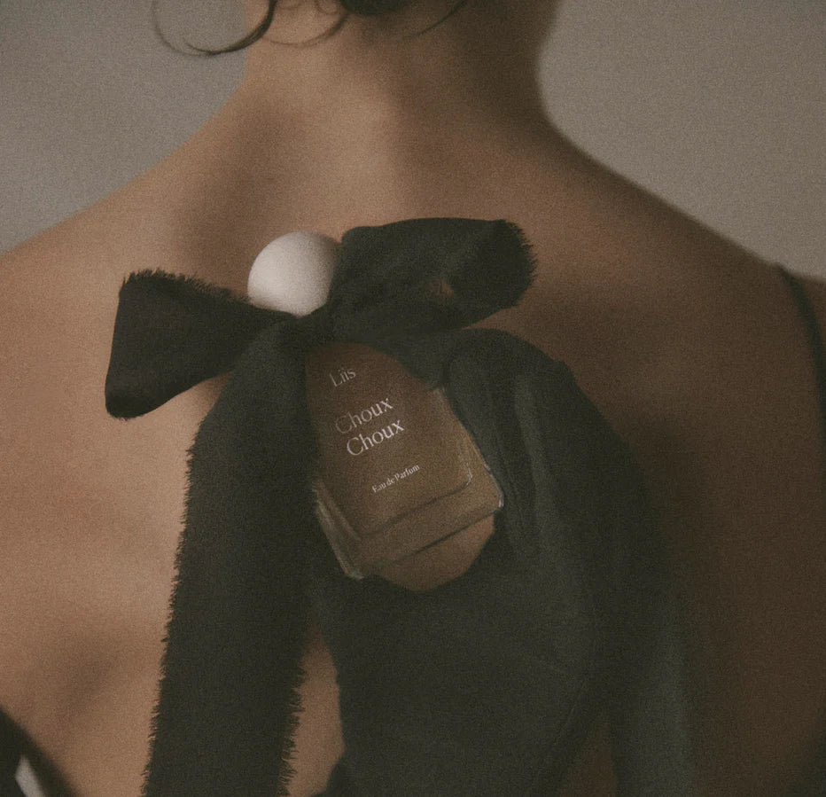Liis Choux Choux Eau de Parfum Flakon in der Hand vor warmer, hautnaher Inszenierung
