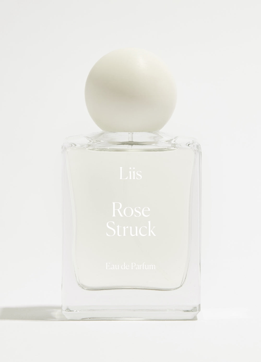 Liis Rose Struck Eau de Parfum Flakon minimalistisch vor hellem Flieder-Hintergrund