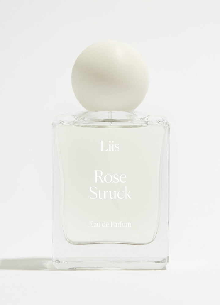 Liis Rose Struck Eau de Parfum Flakon minimalistisch vor hellem Flieder-Hintergrund