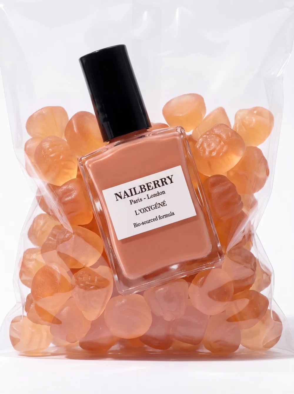 Nailberry Made You Blush Nagellack neben pfirsichfarbenen Steinen