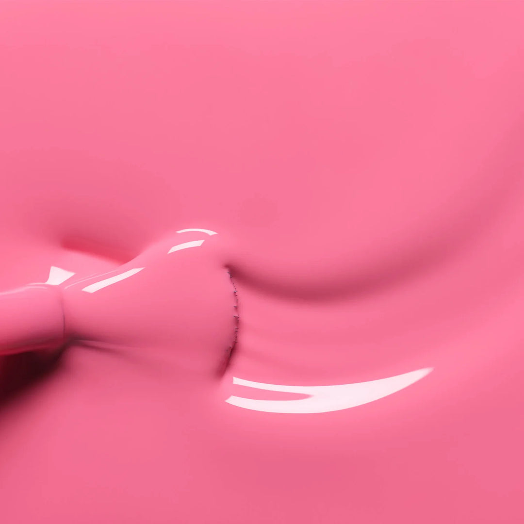 Nahaufnahme des Manucurist Rose Nagellackpinsels, der die leuchtende pinke Formel und glatte Auftragstextur vor passendem rosa Hintergrund zeigt