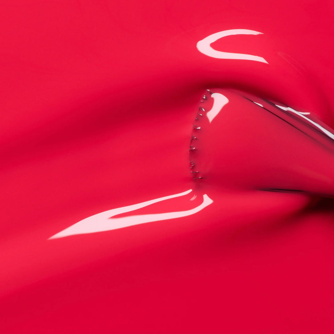 Nahaufnahme des Manucurist Bougainvillea Nagellackpinsels, der die leuchtende korallrote Formel und glatte Auftragstextur zeigt