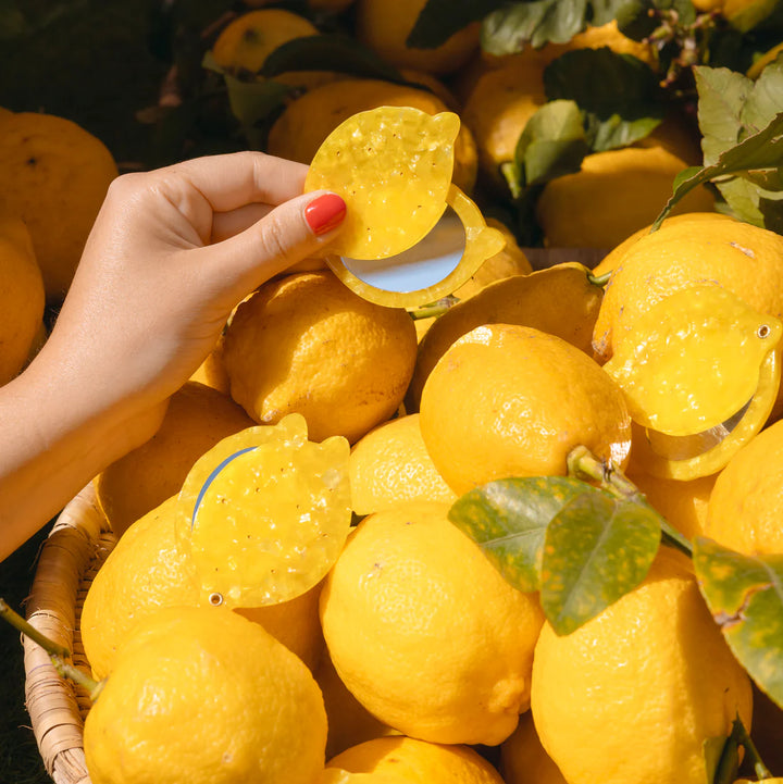 Lemon Mirror von Coucou Suzette - gehalten in der Hand, mit vielen Zitronen