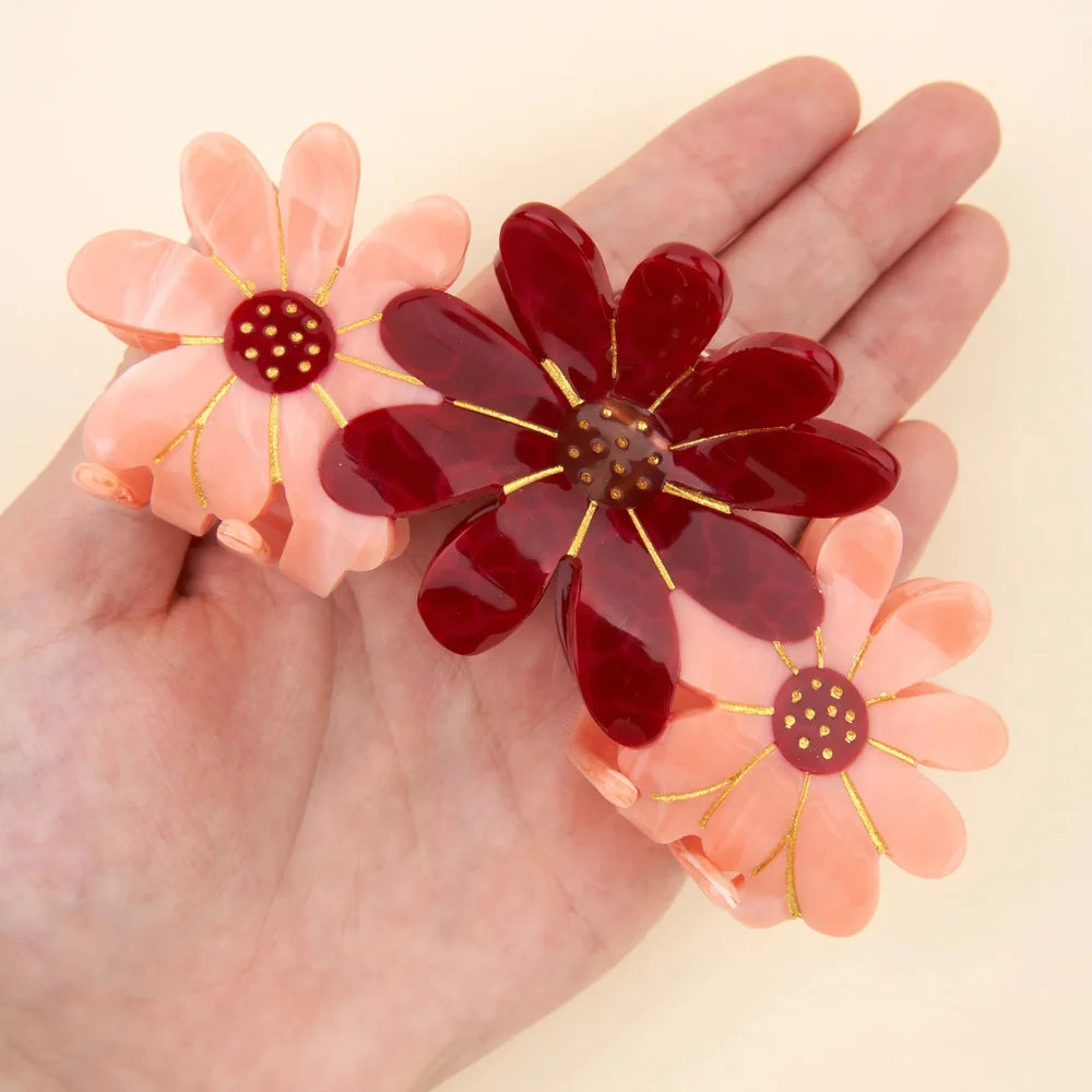 Pink Flower Trio Hair Claw von Coucou Suzette auf einer Handfläche