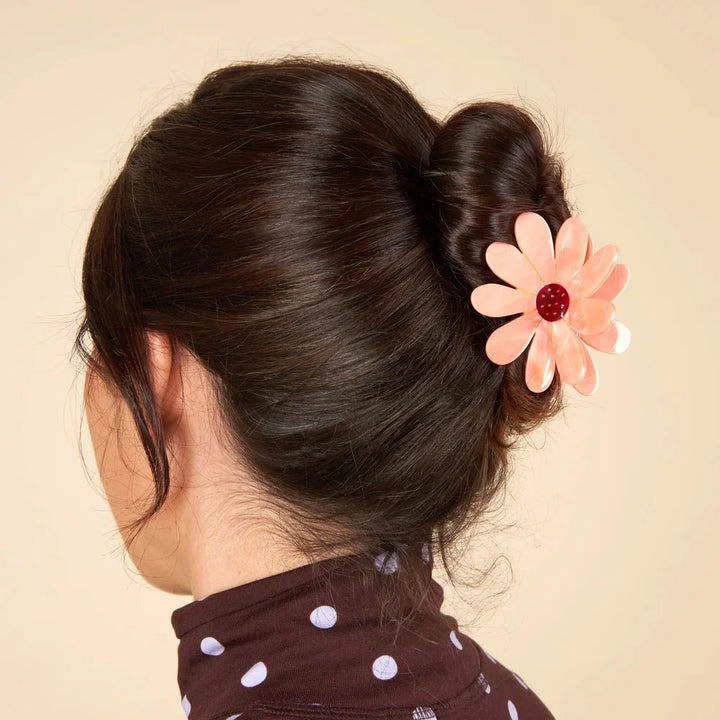 Rosa Flower Hair Claw von Coucou Suzette an einem dunklen Dutt getragen