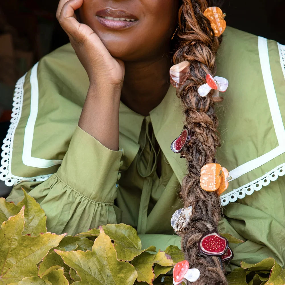Verschiedene Coucou Suzette Haarspangen in einem geflochtenen Zopf, darunter die Igel Mini-Haarklammer