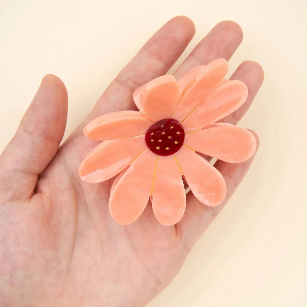Pink Flower Hair Claw von Coucou Suzette auf einer Handfläche