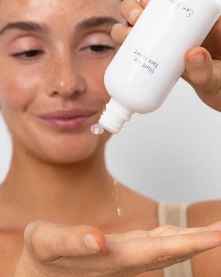 Ere Perez Black Tea Face Toner wird in die Handfläche dosiert – leichter Toner zur täglichen Gesichtspflege