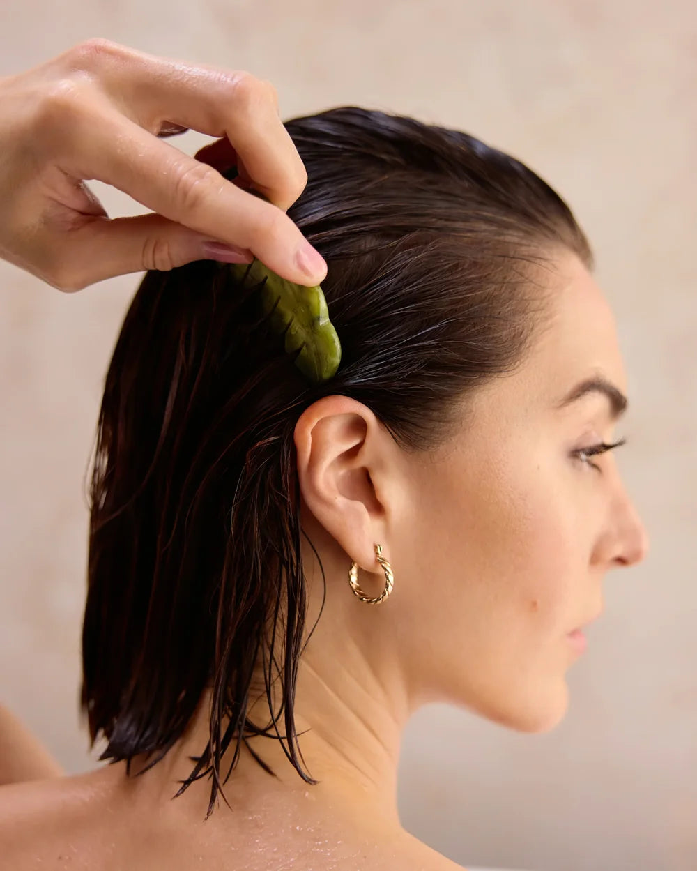 Frau kämmt sich durchs nasse Haar nach der Anwendung des Scalp Exfolating Shampoo