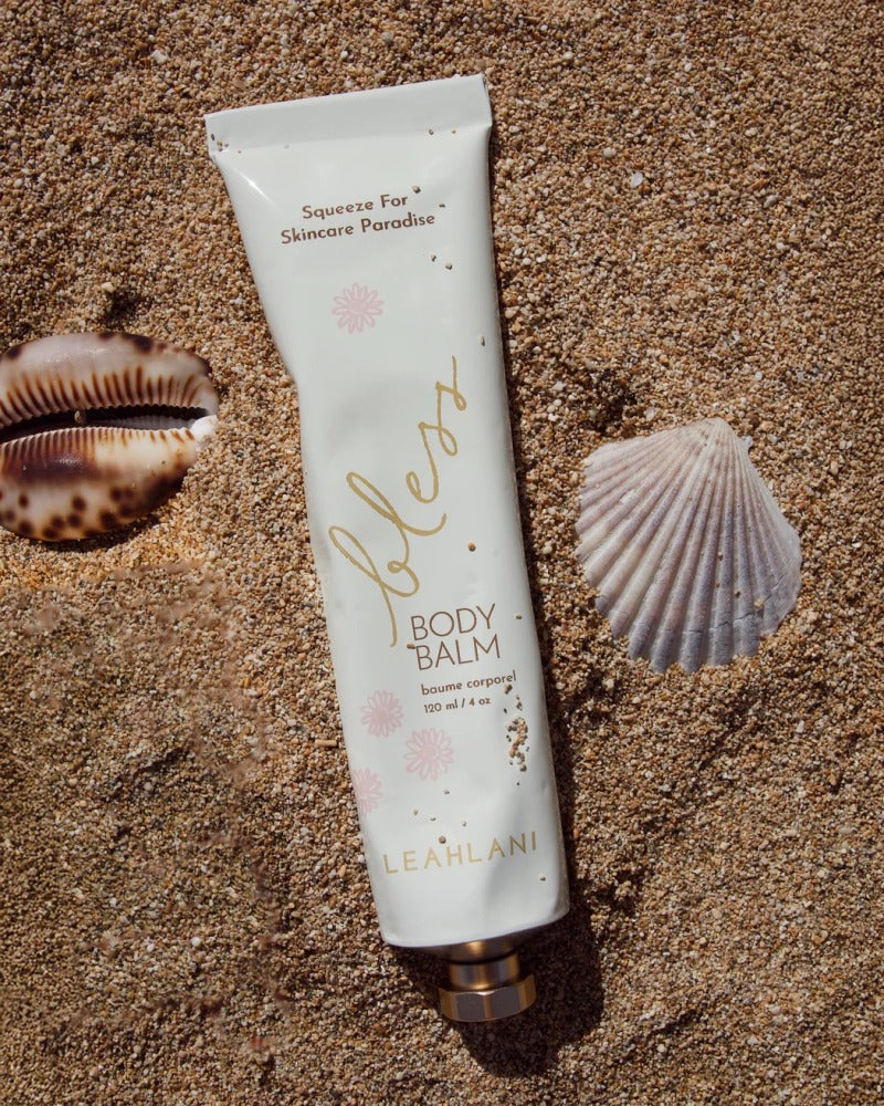 Bless Body Balm von Leahlani - auf Sand neben Muscheln