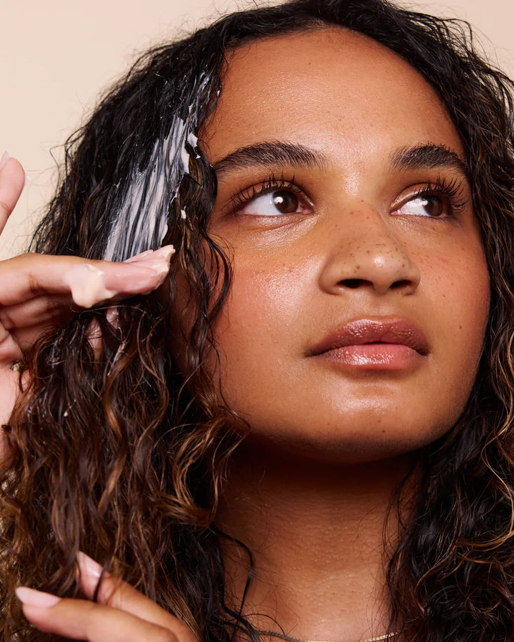 Frau mit Rahua Enchanted Island Vegan Curl Butter im Haar