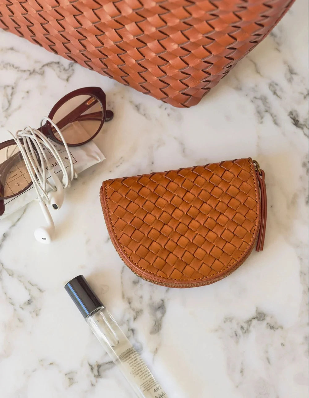 O My Bag Laura Coin Purse Cognac – geflochtene Ledergeldbörse mit persönlichen Accessoires arrangiert