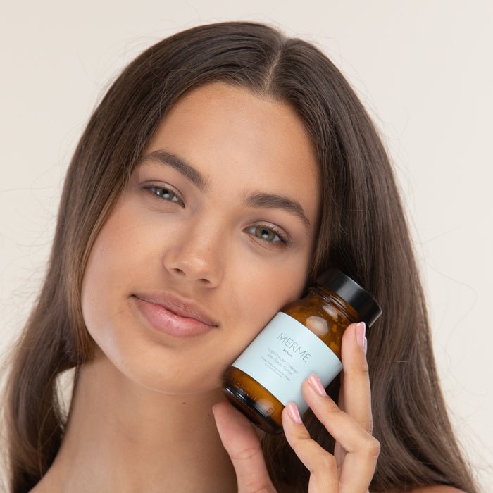 Merme Facial Cleansing Oil - model with product next to face