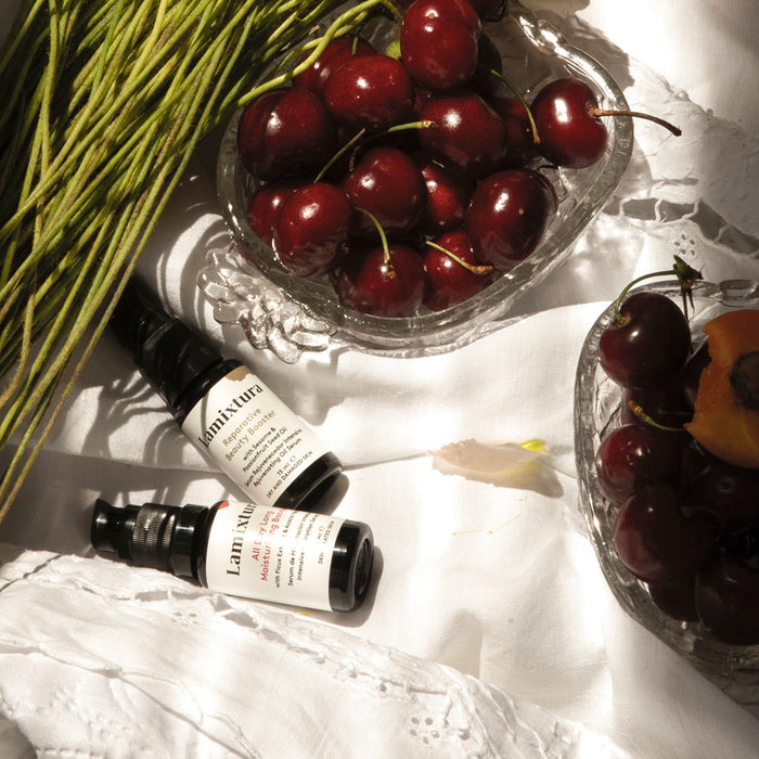 Lamixtura All Day Moisturizing and Reparative Booster next to cherries