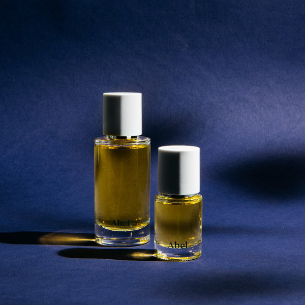 Abel Cobalt Amber Perfume regular and small size in front of blue background
