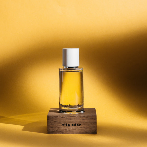 Abel Perfume de Neroli dorado encima de un trozo de madera