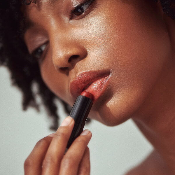 Henné Organics Luxury Lip Tint Intrigue - mujer aplicándose a los labios
